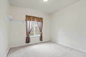 Carpeted spare room featuring baseboards
