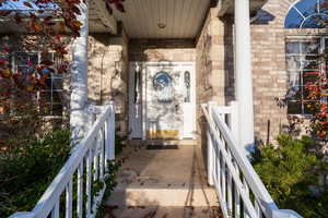 Doorway to property featuring brick siding