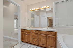 Full bath featuring double vanity, light colored carpet, a tub, light tile patterned floors, and a closet