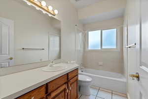 Bathroom featuring vanity, shower / washtub combination, and light tile patterned flooring