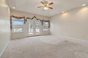 Unfurnished room featuring healthy amount of natural light, a raised ceiling, recessed lighting, and ceiling fan