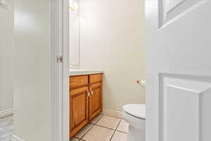 Half bath with vanity and light tile patterned floors