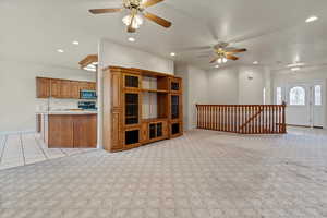 Unfurnished living room with ceiling fan, light carpet, recessed lighting, and light tile patterned floors