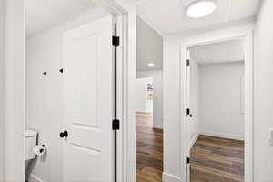 Hallway with dark wood-style flooring and baseboards