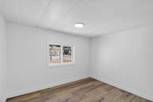 Spare room with a textured ceiling and wood finished floors