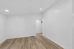 Spare room with wood finished floors, recessed lighting, and lofted ceiling