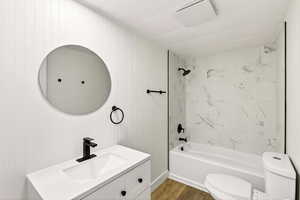 Full bath featuring tub / shower combination, vanity, and wood finished floors