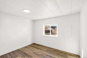 Spare room with wood finished floors and a textured ceiling