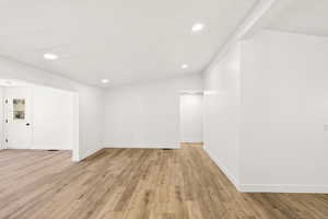 Empty room featuring light wood-style floors and recessed lighting