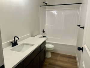Full bath with vanity, shower / tub combination, and dark wood-type flooring
