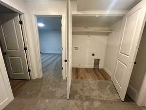 Laundry area with dark colored carpet, hookup for a washing machine, and hookup for an electric dryer