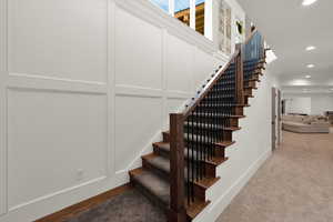 Staircase featuring recessed lighting, carpet floors, and a decorative wall
