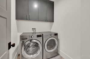 Washroom featuring separate washer and dryer and cabinet space