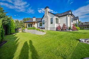 Back of house featuring a chimney and a patio