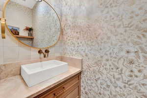 Bathroom with vanity and tasteful backsplash
