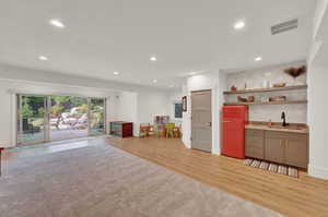 Rec room with light wood finished floors and recessed lighting