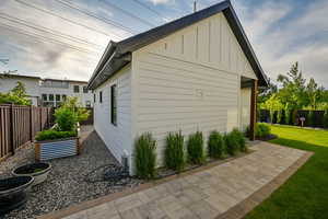 View of side of home featuring a fenced backyard, board and batten siding, and a vegetable garden