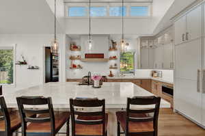 Kitchen featuring open shelves, pendant lighting, decorative backsplash, and a spacious island