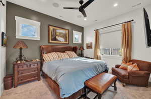 Bedroom with multiple windows, light carpet, ceiling fan, and recessed lighting