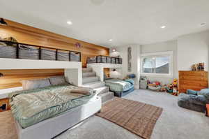 Bedroom with carpet, recessed lighting, and wooden walls