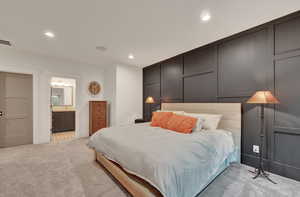 Bedroom featuring light colored carpet, a decorative wall, and recessed lighting