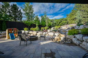 Fenced backyard featuring an outdoor fire pit and a patio