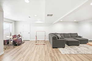 Living area featuring light wood finished floors and recessed lighting