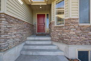 Entrance to property featuring stone siding