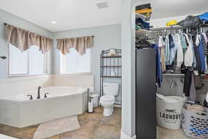 Full bathroom with a garden tub and a walk in closet
