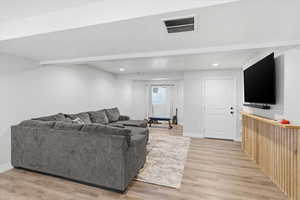 Living room with light wood-style flooring, a textured ceiling, and recessed lighting