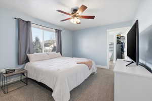 Bedroom featuring carpet, ceiling fan, and ensuite bathroom