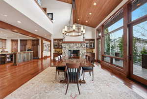 Dining area with light wood-type flooring, recessed lighting, a chandelier, a wood ceiling with exposed beams, and high vaulted ceiling