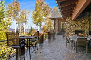 View of patio featuring outdoor dining space and an outdoor stone fireplace