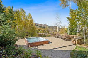 View of yard with a patio, a hot tub, and a mountain view