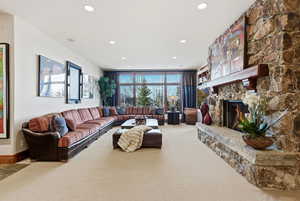 Carpeted living area featuring a fireplace and recessed lighting