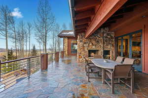 View of patio featuring an outdoor stone fireplace, outdoor dining area, and french doors