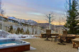 View of patio / terrace featuring a fire pit, a mountain view, and a hot tub