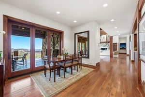 Dining area with light wood-type flooring, recessed lighting, and a large fireplace