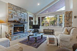 Living area featuring carpet floors, a fireplace, and high vaulted ceiling