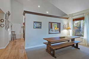 Dining room featuring high vaulted ceiling, light wood finished floors, and recessed lighting