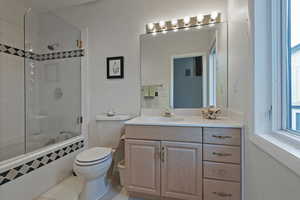 Full bath with tiled shower / bath, vanity, and light tile patterned floors