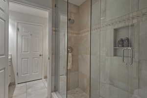 Full bath featuring a stall shower, light tile patterned floors, and vanity