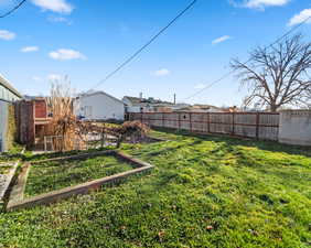Fenced backyard featuring a garden