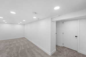 Finished basement featuring light carpet and recessed lighting