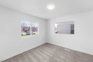 Carpeted spare room with baseboards