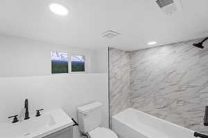 Bathroom featuring bathtub / shower combination, vanity, and recessed lighting
