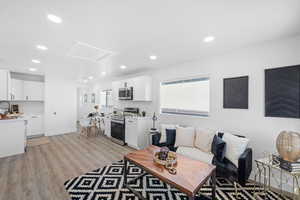 Living area with light wood-type flooring, recessed lighting, and attic access
