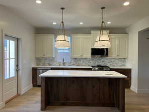 Kitchen featuring decorative backsplash, dark brown cabinetry, recessed lighting, light wood-style floors, and decorative light fixtures