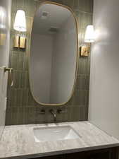 Bathroom featuring vanity and tasteful backsplash