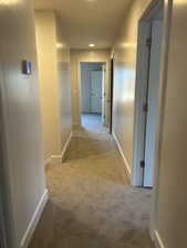Corridor with light carpet and recessed lighting
